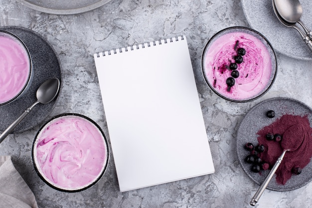 Delicious açai bowl arrangement with empty notepad