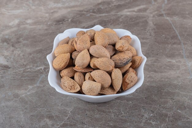 Delicious almonds in the bowl on the marble surface