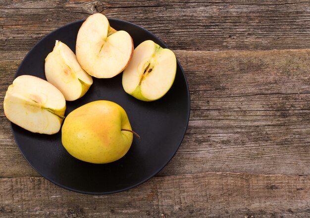 木製のテーブルの上の皿においしいリンゴ