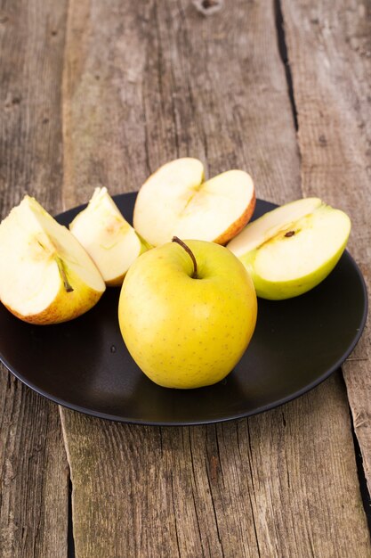 delicious apple on a plate over a wooden table