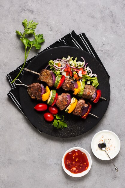 Delicious arabic fast-food skewers on black plate