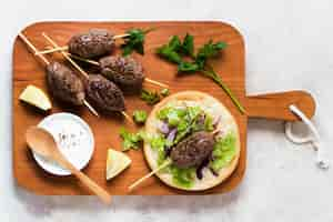 Free photo delicious arabic fast-food skewers on wooden board