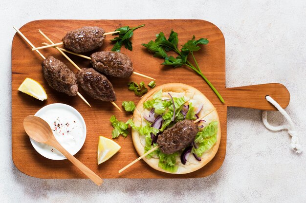 Delicious arabic fast-food skewers on wooden board