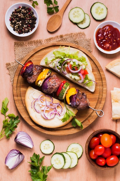 Delicious arabic fast-food veggies and meat on skewers flat lay