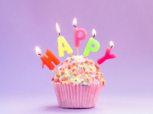 Delicious birthday muffin with colorful candles