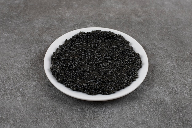 Free photo delicious black caviar on white bowl on white plate