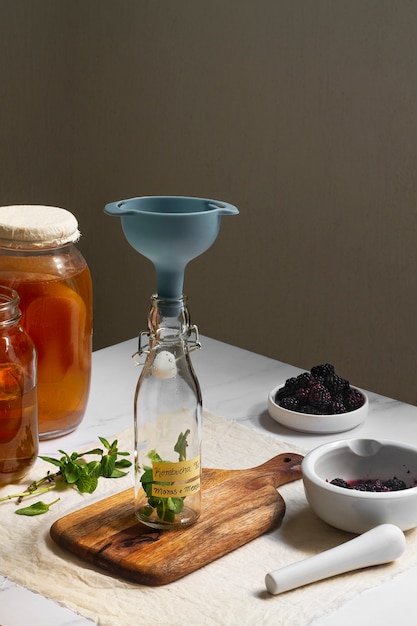 Free photo delicious blackberries kombucha bottle still life