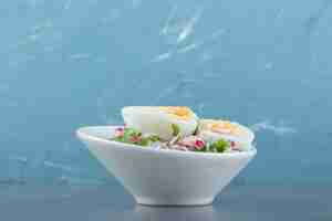 Free photo delicious boiled eggs and fresh salad in white bowl