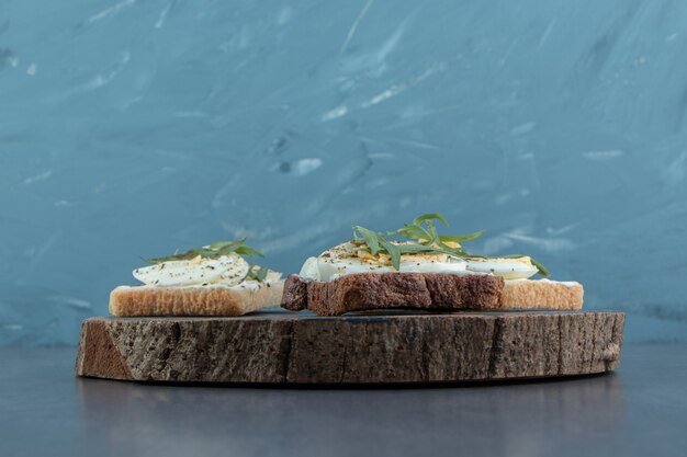 Delicious boiled eggs with toast bread on wood piece.