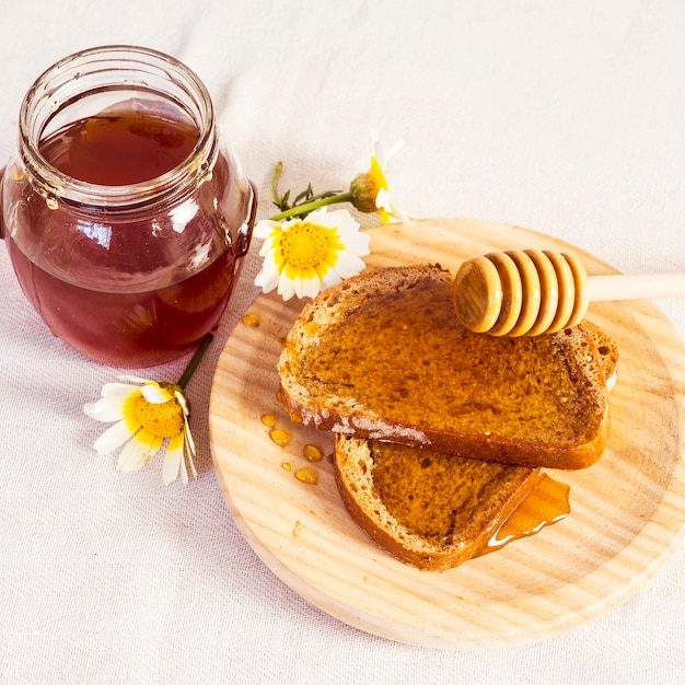 Delicious bread and honey in wooden plate