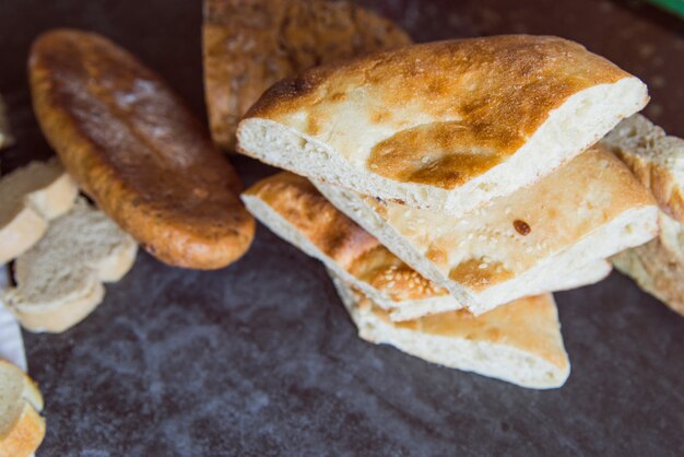 Delicious bread on slate board close up