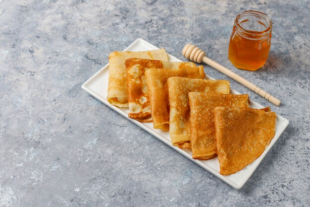Delicious Breakfast. Orthodox holiday Maslenitsa. Crepes with cumquats and honet, top view