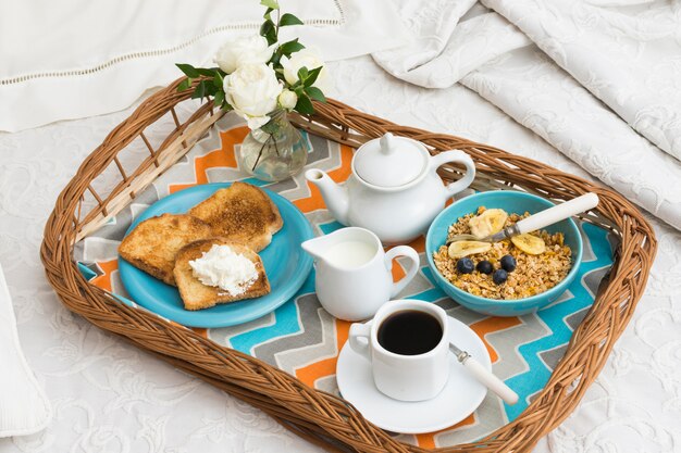 Delicious breakfast tray on bed