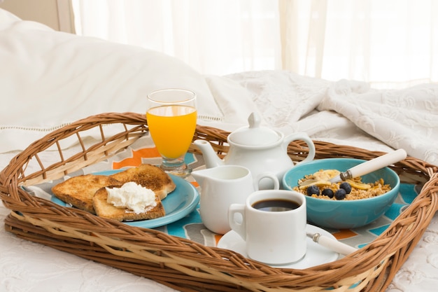 Delicious breakfast tray on bed