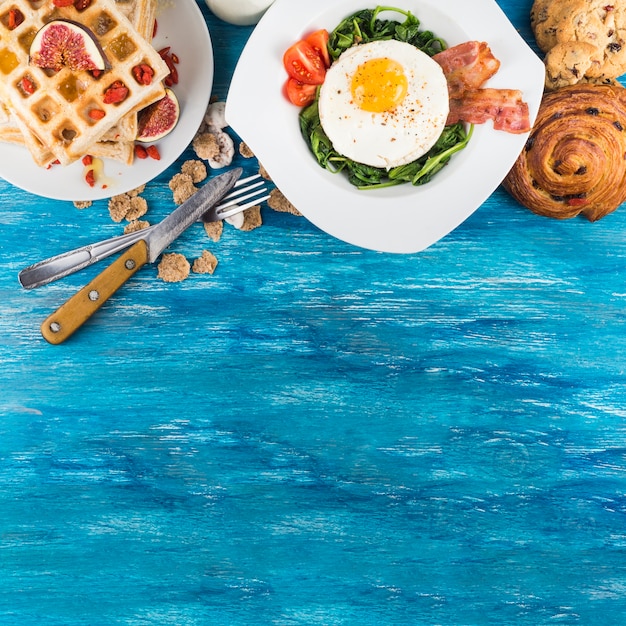 Delicious breakfast with pastries on wooden textured background