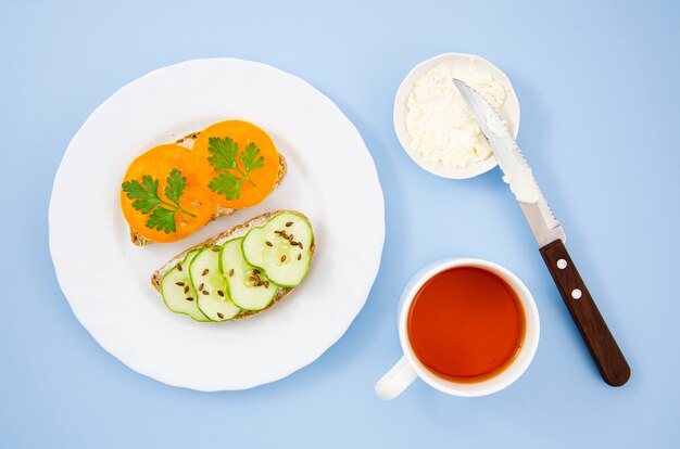 Foto gratuita deliziosa colazione con panini vegetariani e una tazza di tee