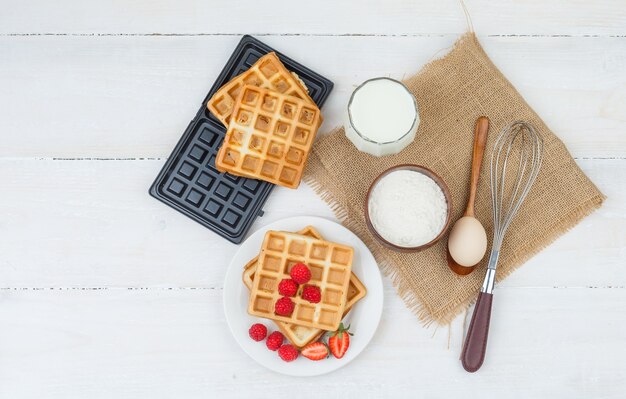 Delicious breakfast with waffles, milk and berries