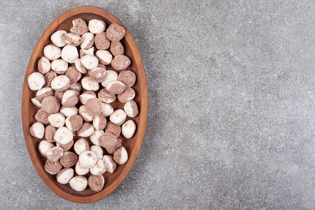 Delicious brown candies on wooden plate