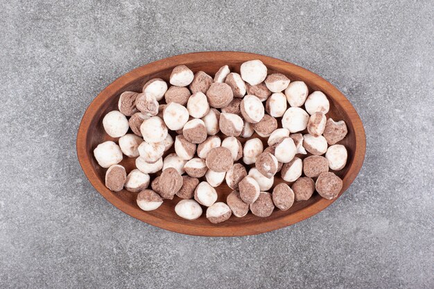 Delicious brown candies on wooden plate