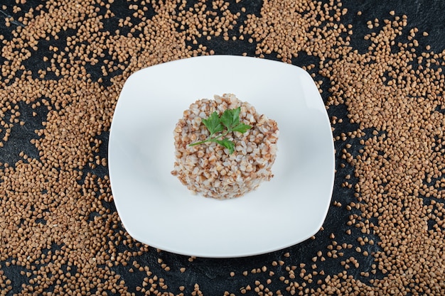 Free photo delicious buckwheat with greens on white plate.