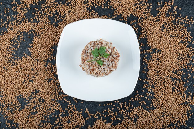 Delicious buckwheat with greens on white plate.