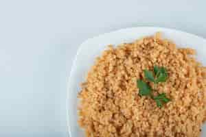 Foto gratuita delizioso pilaf di bulgur su un piatto bianco