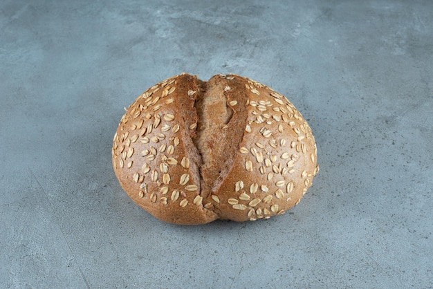 Delicious bun with seeds on marble.