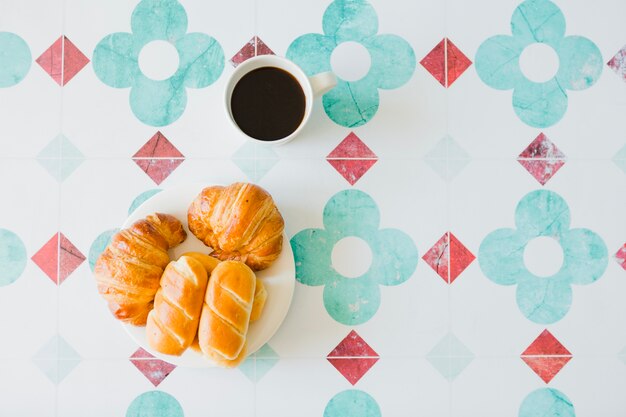 Delicious buns and coffee in composition