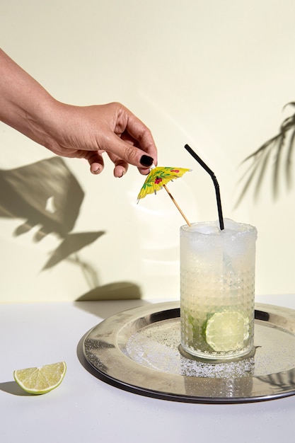 Delicious caipirinha cocktail with straw and umbrella