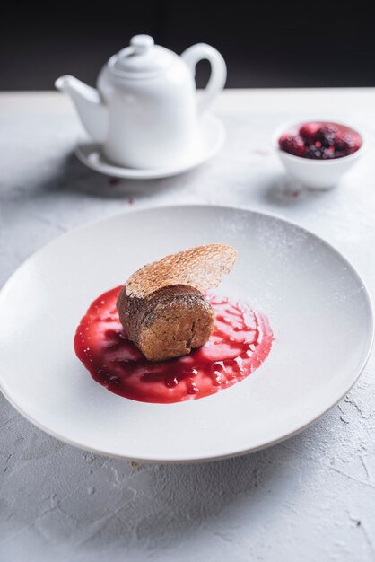 Delicious cake on berries sauce over the ceramic white plate