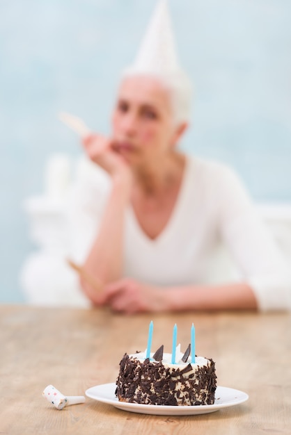 Delicious cake in front of defocused woman