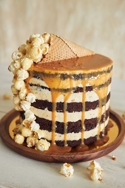 Delicious cake topped with caramel cream and a cone filled with popcorn on it