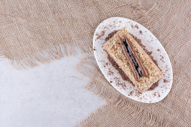 Delicious cake on white plate with burlap.