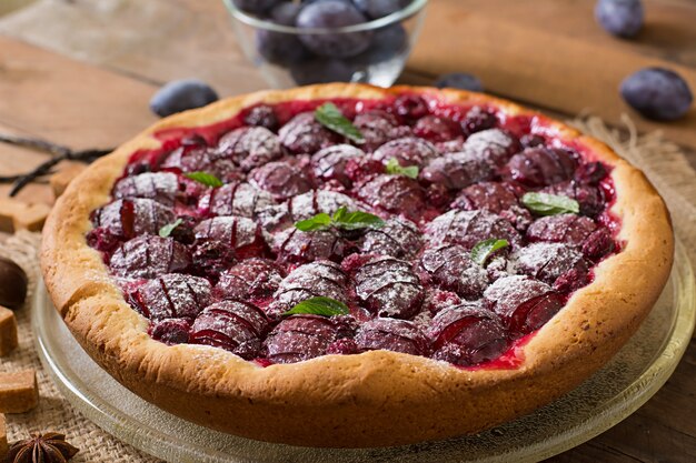 Delicious cake with fresh plums and raspberries