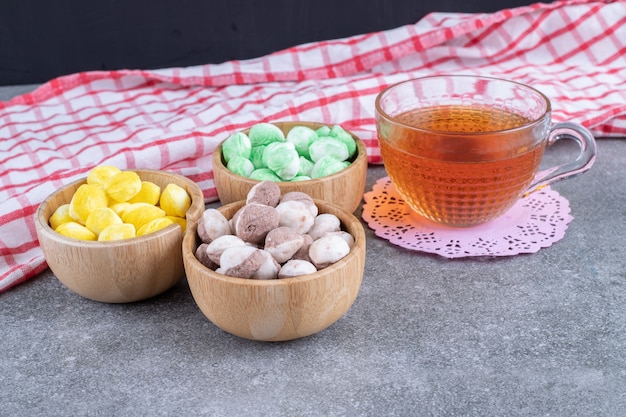 Deliziose caramelle e tazza di tè sulla superficie di marmo