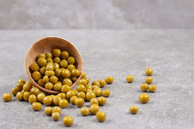 Delicious canned peas in wooden bowl