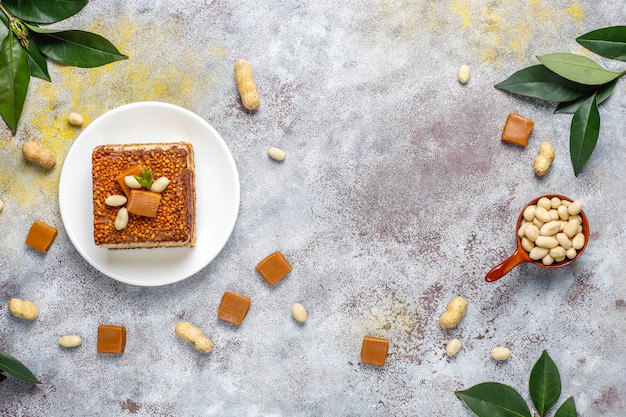 Free photo delicious caramel and peanut cake with peanuts and caramel candies, top view