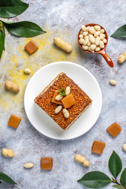 Free photo delicious caramel and peanut cake with peanuts and caramel candies, top view