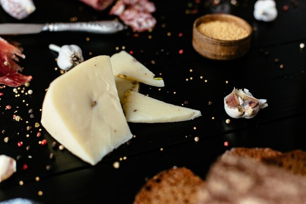 黒い木製のテーブルにフェスタシカミとおいしいチーズ