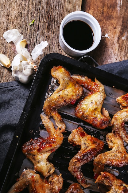 Foto gratuita deliziose ali di pollo sul tavolo di legno