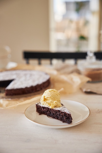 미적 세부 사항이 있는 흰색 테이블에 크림을 넣은 맛있는 초콜릿 케이크