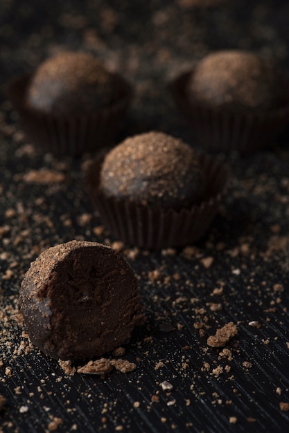 Delicious chocolate candies with the crumbs on the black surface