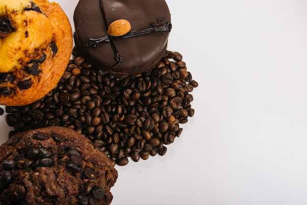 Delicious chocolate mini cakes near coffee beans 