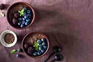 Free photo delicious chocolate mousse or panna cotta with blueberries and blueberries on a dark fabric background