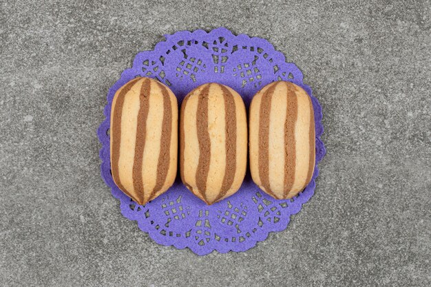 Free photo delicious chocolate striped biscuits on blue napkin
