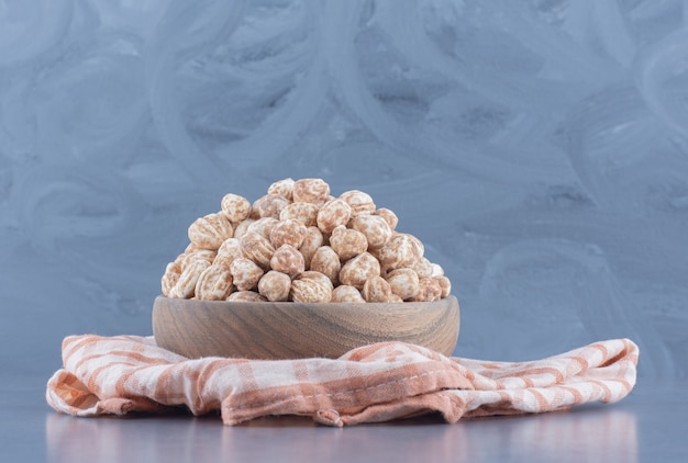 Delicious cinnamon candies in the bowl, on the marble background. 