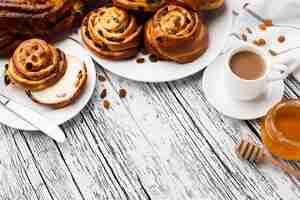 Free photo delicious cinnamon raisins rolls on wooden table