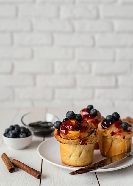 Foto gratuita deliziosi panini alla cannella con frutta e guarnizione