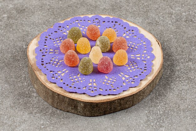 Delicious colorful marmalade, on wooden board.