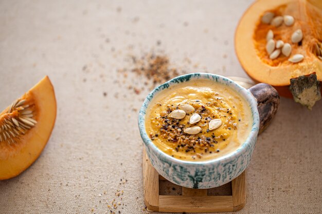Delicious composition with pumpkin soup in a beautiful ceramic dish. Seasonal food.